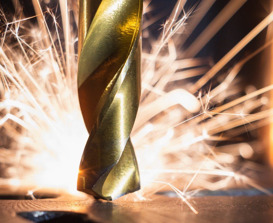 industrial drill bit with sparks in the distance
